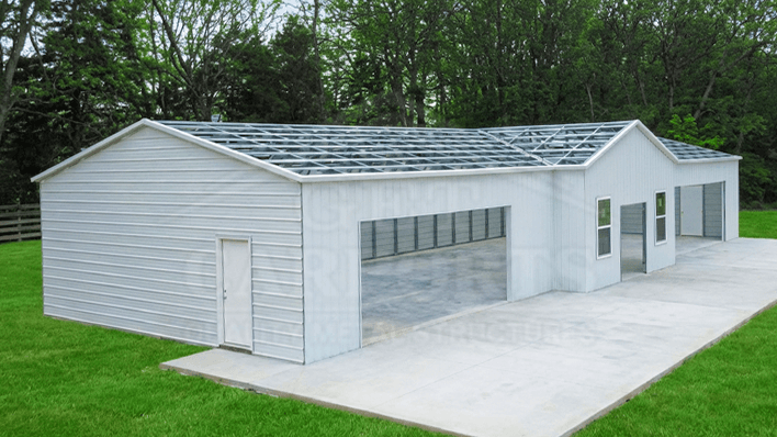 Light gray residential barndominium with navy vertical roof, walk-in doors, and covered side porch — Get Carports